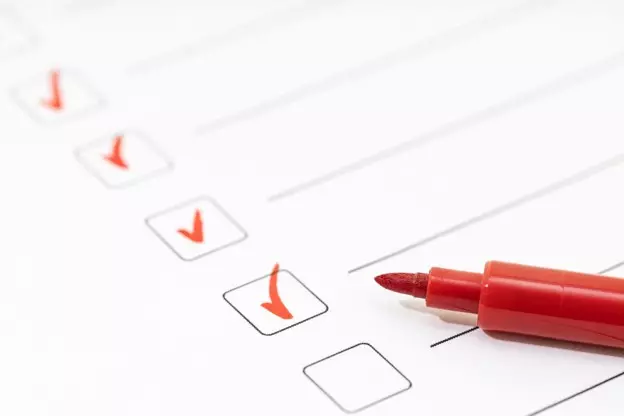 Checklist with completed items and a red marker used for evaluation