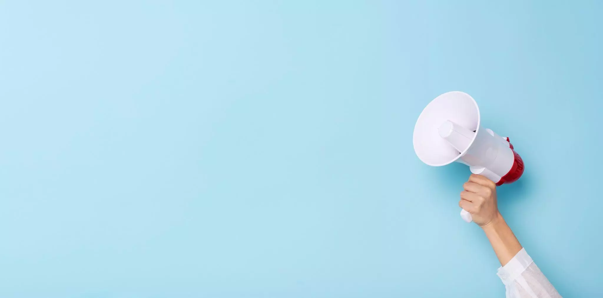 Hand holding a red and white megaphone against a light blue background, representing brand mentions and AI visibility